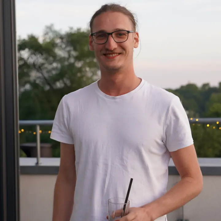 Tim Pfeifer smiling on a rooftop terrace at dusk